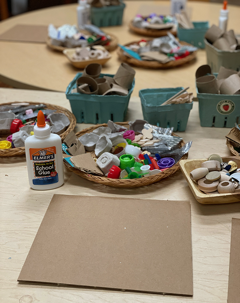 Setting up cardboard and recycled materials on a table to make collages for preschoolers